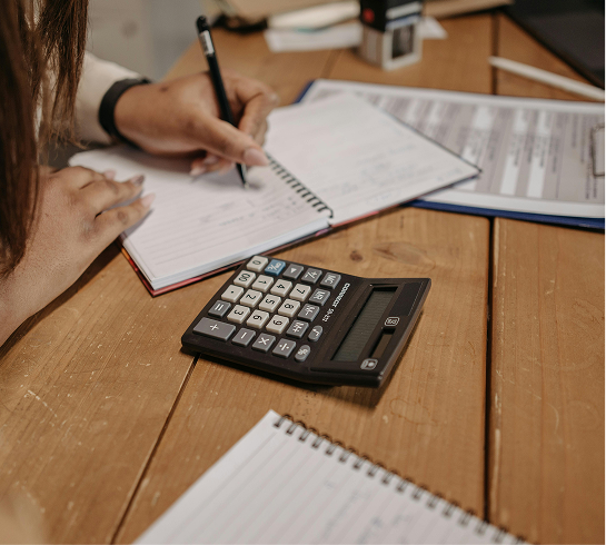 Person reviewing financial paperwork with calculator.