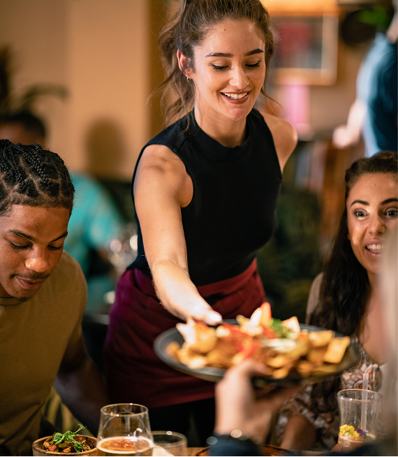 Restaurant server delivering food to table.