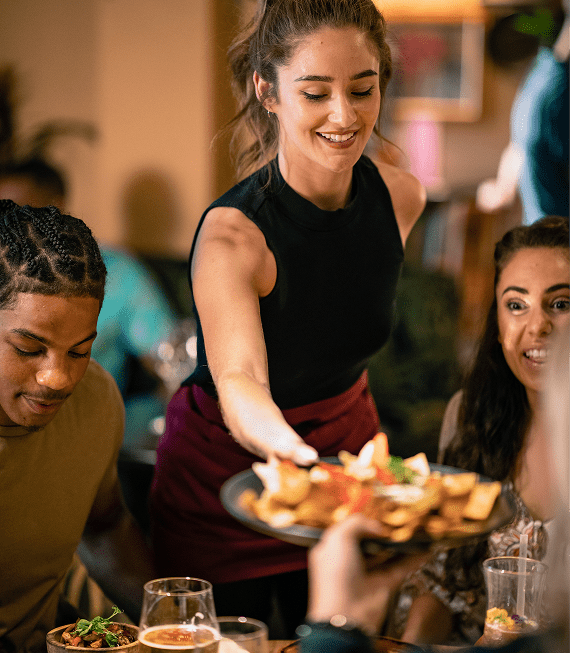 Restaurant server delivering food to table.